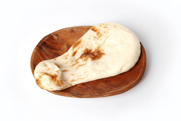 индийский хлеб на тарелке на белом фоне - Фото, изображение