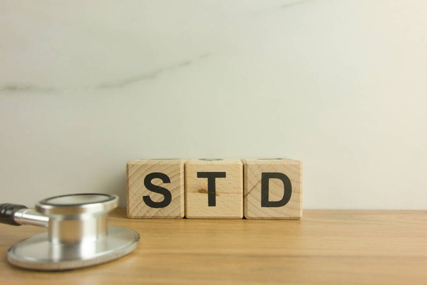 STD - Szexuális úton terjedő betegségek mozaikszó fa blokkok sztetoszkóppal. Orvosi és egészségügyi koncepció - Fotó, kép