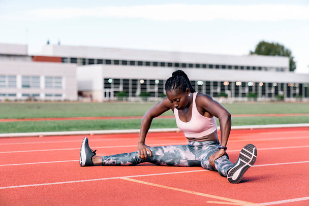 Athlete sprinter stretching her legs - Fotó, kép