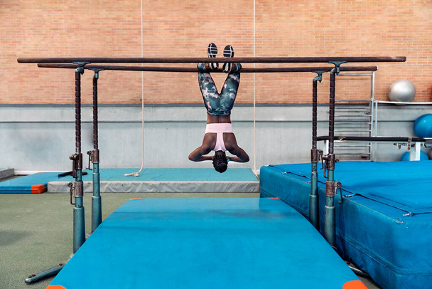 Athlete practicing on parallel bars - Foto, afbeelding