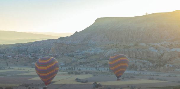 Hot air balloons. Landed hot air balloons in Cappadocia at sunrise. Travel to Turkey background photo. - Fotó, kép