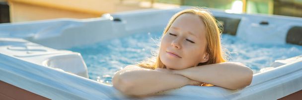 BANNER, LONG FORMAT Portrait of young carefree happy smiling woman relaxing at hot tub during enjoying happy traveling moment vacation life against the background of green big mountains - Fotografie, Obrázek