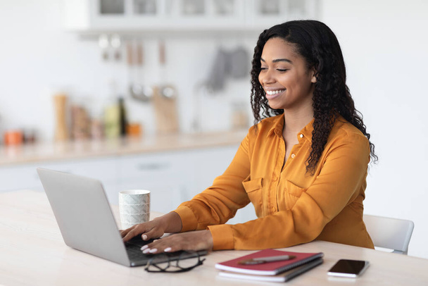 Happy african american woman using laptop at home - Φωτογραφία, εικόνα