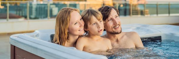 BANNER, LONG FORMAT Portrait of young carefree happy smiling happy family relaxing at hot tub during enjoying happy traveling moment vacation. Life against the background of green big mountains - Photo, Image