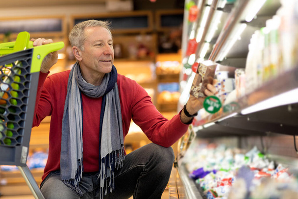 Щасливий чоловік пенсіонер купує їжу в супермаркеті
 - Фото, зображення