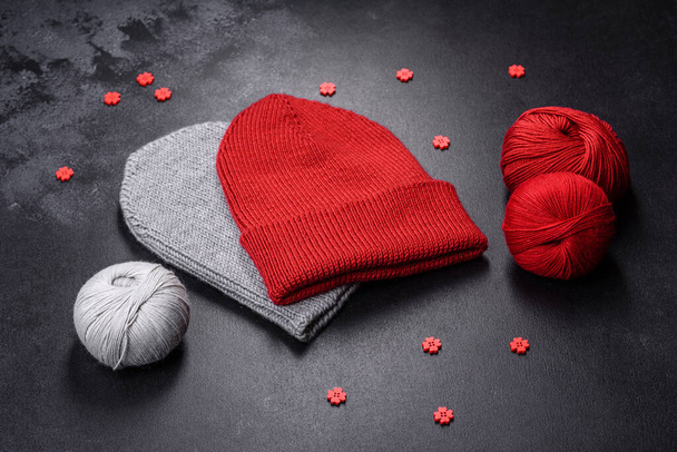 Czerwony, ciepły damski kapelusz na betonowym tle. Zainteresowania i czas wolny - Zdjęcie, obraz