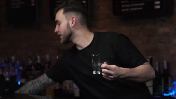 Cantinero es un hombre joven El tipo vierte bebidas, prepara tragos alcohólicos Medusa en el bar - Imágenes, Vídeo