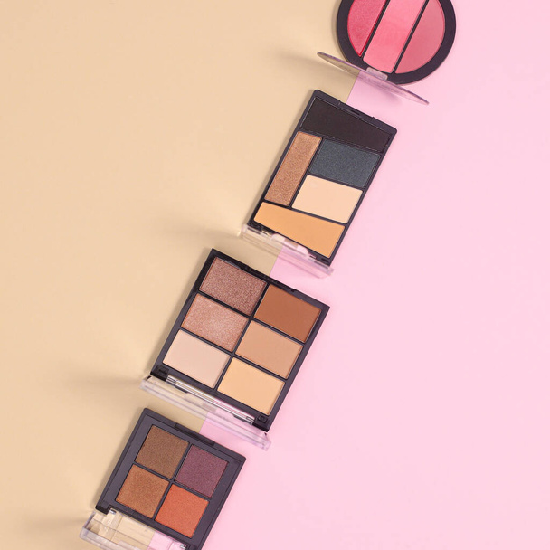 Eye shadows make up products commposition on pastel beige and pink background. Flat lay minimal skin care fashion concept - Zdjęcie, obraz