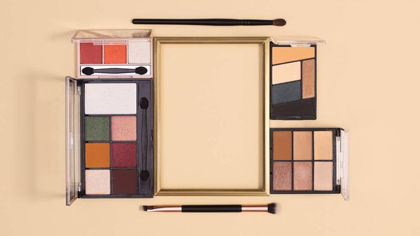 Golden copy space frame with make up products on pastel beige background. Flat lay - Foto, immagini