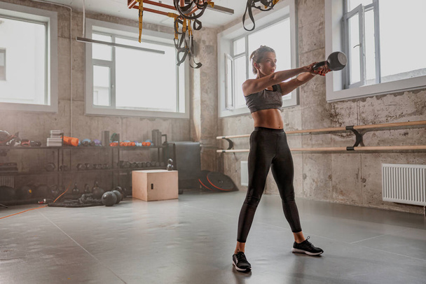 Fit femme faisant de l'exercice avec kettlebell dans la salle de gym - Photo, image