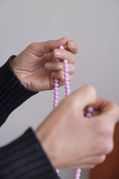 Mãos de oração focadas seletivas de mulher muçulmana com rosário rosa. - Foto, Imagem