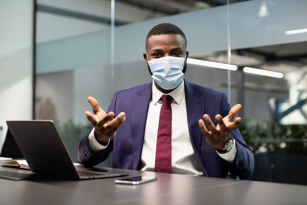 Black manager in face mask working at office, having conference - Foto, imagen