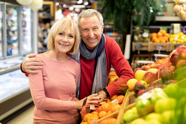 Attractive elderly couple posing at supermarket, copy space - Photo, Image