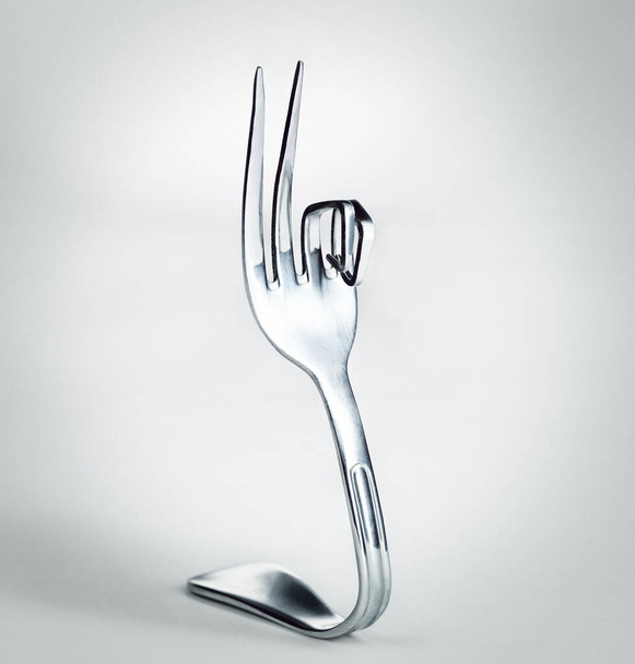 A-OK. A fork with bent prongs isolated on grey. - Фото, изображение