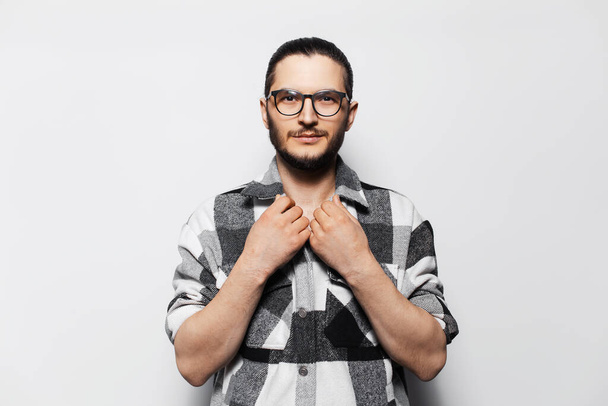 Studio portrait of young attractive man, wearing plaid shirt and glasses. - Фото, зображення