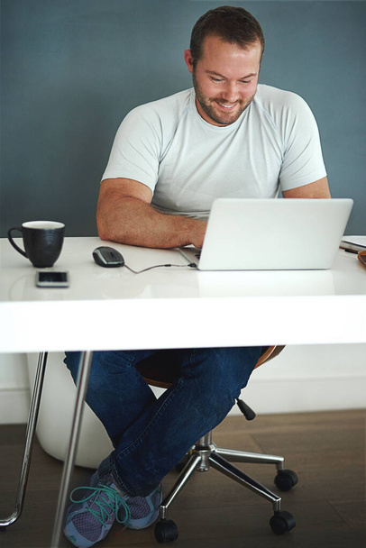 Blog yazmaktan zevk alıyor. Dizüstü bilgisayarıyla çalışan genç bir adamın tam boy görüntüsü.. - Fotoğraf, Görsel