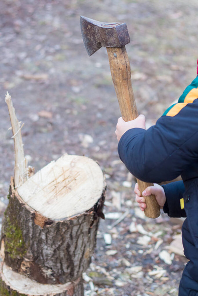 Dziecko rąbiące drewno siekierą w zimie na Ukrainie - Zdjęcie, obraz