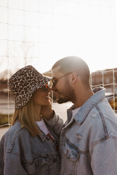 Girlfriend and boyfriend in the fence looking each other and touching noses. Happy couple. - 写真・画像