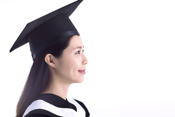 Boční pohled na mladé asijské ženy studentů na sobě maturitní klobouk a šaty - Fotografie, Obrázek