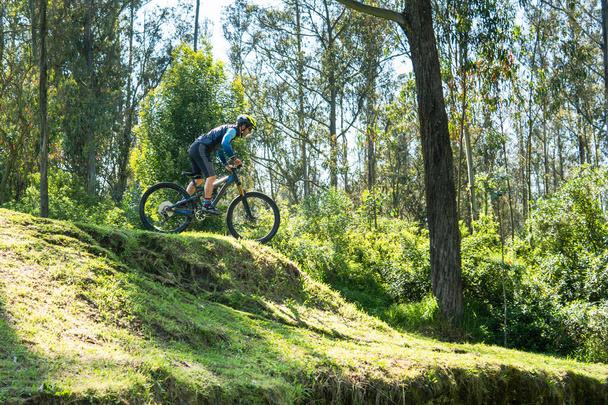 hombre montando su bicicleta por una montaña a través de un bosque. Concepto deportivo - Foto, Imagen