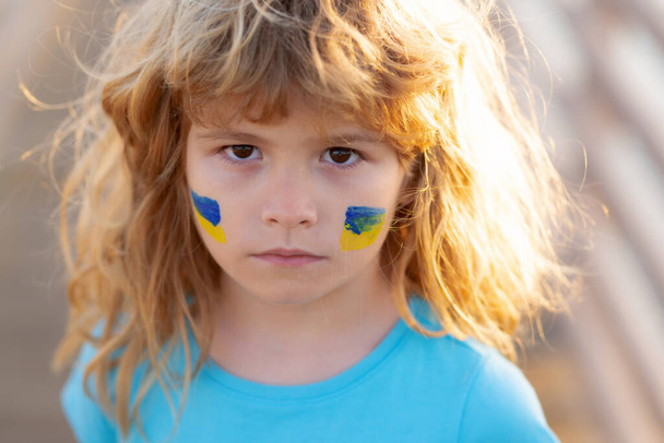 Bandeira da Ucrânia na bochecha das crianças. Proteger salvar crianças ucranianas. Sem guerra, acabar com a guerra, agressão russa. Pequeno patriota ucraniano. - Foto, Imagem