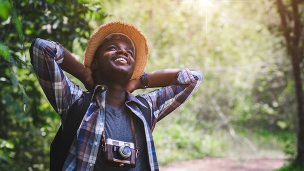 フィルムカメラを保持して休暇中の野生旅行ハイキングでアフリカの男性観光客の旅行,アドベンチャー旅行のコンセプト - 写真・画像