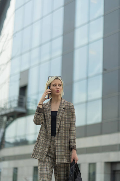 Female boss is talking with her asistent on the phone while walking - Foto, Imagem