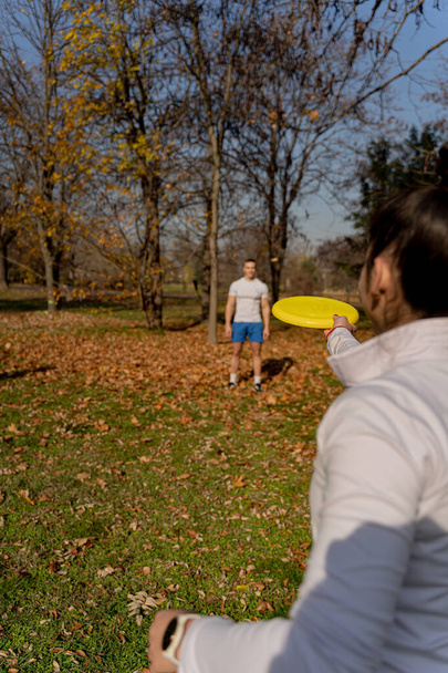 Two attractive and amazing fit friends are playing frisbee outside while having a fun time - Fotó, kép