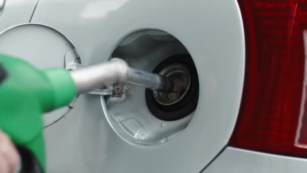Egy benzinkutas keze benzint tesz a kocsiba. - Felvétel, videó