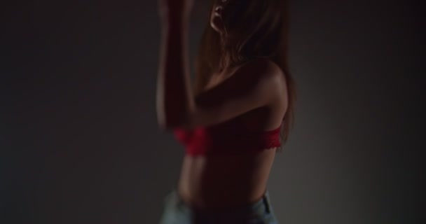 Cool dívka v podprsence a džínách pohybující se svůdně, zpomalený pohyb, mělká hloubka pole, selektivní ostření, silueta - Záběry, video