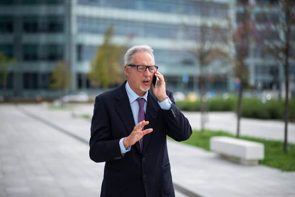 Portrait of a senior businessman using a cell phone - Photo, Image