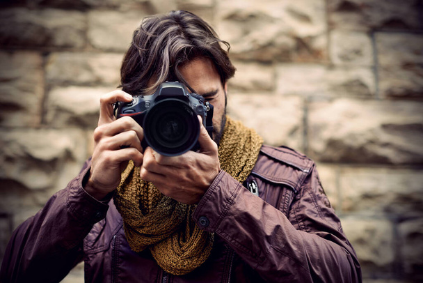 Photography is my passion. Shot of a handsome young photographer at work in the city. - Foto, Imagen