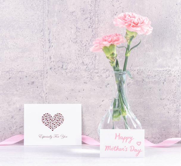 Mothers day handmade giftbox surprise wishes photography - Beautiful blooming carnations with pink ribbon box isolated on gray wallpaper design, close up, copy space, mock up - Foto, Bild