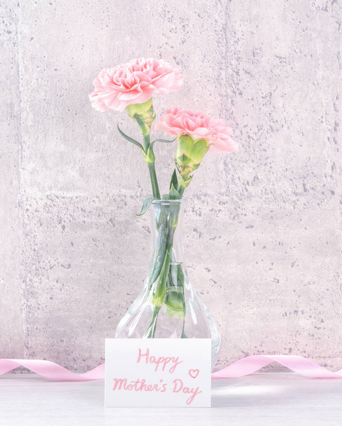 Moederdag handgemaakte geschenkdoos verrassing wensen fotografie - Mooie bloeiende anjers met roze lint doos geïsoleerd op grijs behang ontwerp, close-up, kopieer ruimte, mock up - Foto, afbeelding