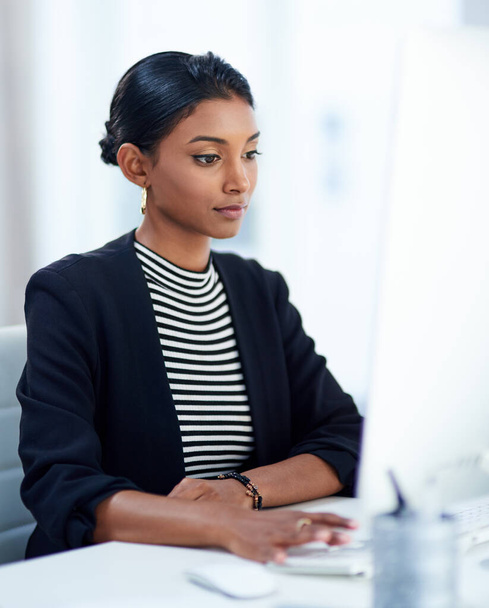 Twoim zadaniem jest odnieść sukces. Zdjęcie atrakcyjnej młodej bizneswoman pracującej na komputerze w swoim biurze. - Zdjęcie, obraz