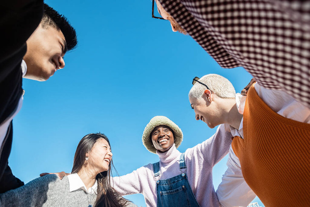 United multiethnic group of friends hugging each other outdoors - Photo, image
