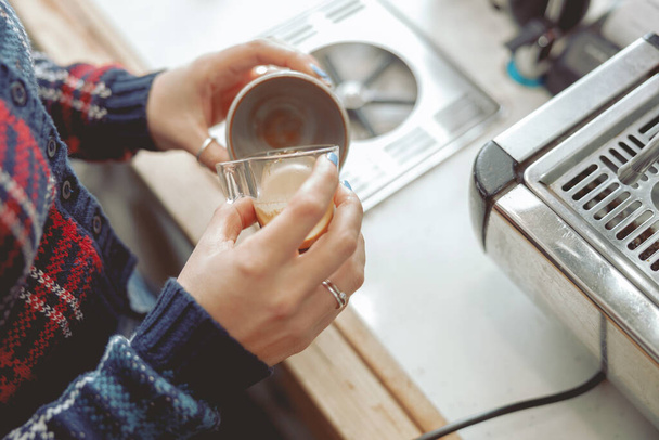 Woman pouring coffee into mug while working in cafe - Фото, зображення
