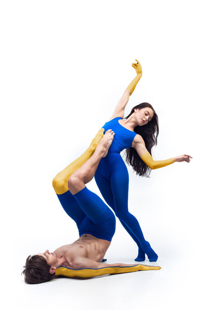 Contemporary art ballet, dance. Flexible young man and woman painted in blue and yellow colors of Ukrainian flag. Concept of feelings, emotions - Fotografie, Obrázek