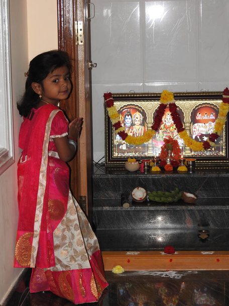 Bangalore, Karnataka, India-Jan 15, 2022: Closeup of beautiful Indian girl kid traditionally dressed to distribute Makara Sankranti or Pongal Prasada to neighborhood. - Photo, Image