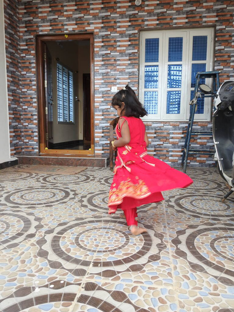 Bangalore, Karnataka, India-Jan 15, 2022: Closeup of beautiful Indian girl kid traditionally dressed to distribute Makara Sankranti or Pongal Prasada to neighborhood. - Photo, Image