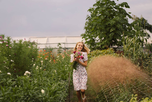 Девочка-подросток ходит с букетом цветов на цветочной цветочной ферме. - Фото, изображение