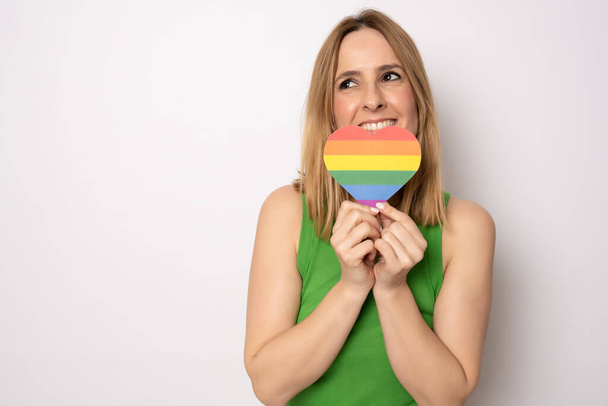 Щаслива жінка, що показує веселку ЛГБТ-серце ізольовано на білому фоні
. - Фото, зображення