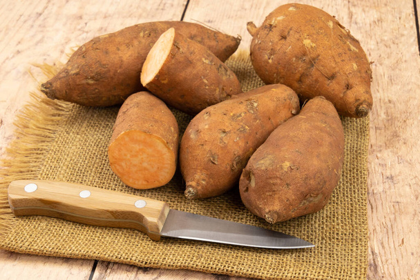 close up of whole and cut sweet potato on burlap - Foto, Imagen