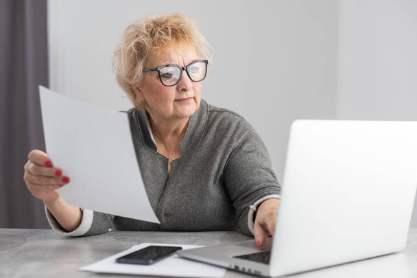 Mulher aposentada calculando suas contas domésticas - Foto, Imagem