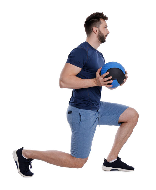 Athletic man doing exercise with medicine ball isolated on white - Фото, изображение