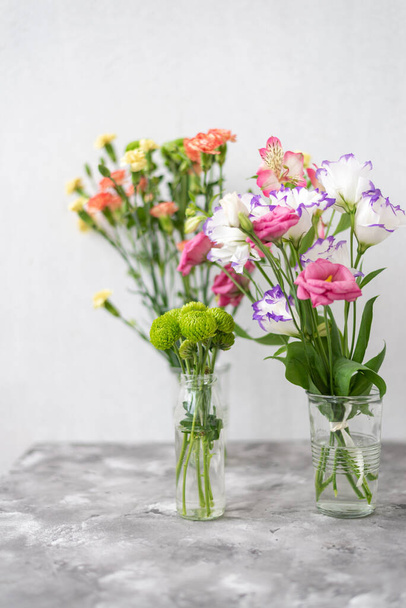 Colorful flowers composition over grey background with copy space. Fresh cut flowers for decoration home. Flower arrangement in a vase for home. Women's Day and spring time flower background - Fotoğraf, Görsel