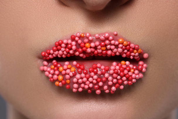 Young woman with beautiful lips covered confectionery sprinkles, closeup - Photo, Image