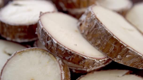 Sliced yucca root. Raw manioc slices. Macro. Rotation. Dried cassava plant - Materiał filmowy, wideo