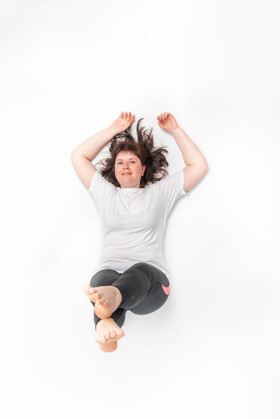 Plump woman does sports. Top view portrait of girl while playing sports on white background - Photo, Image