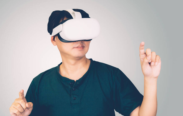 Ritratto di giovane asiatico che indossa occhiali realtà virtuale con eccitato isolato su sfondo bianco, metaverse tecnologia e dispositivo, innovazione per l'intrattenimento e l'istruzione con moderno. - Foto, immagini